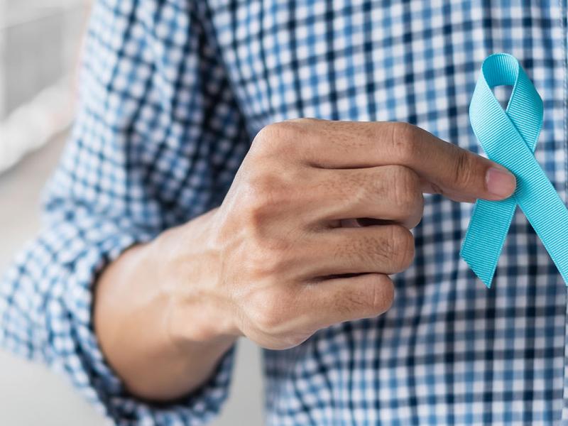 Midsection of Man Holding Blue Ribbon.