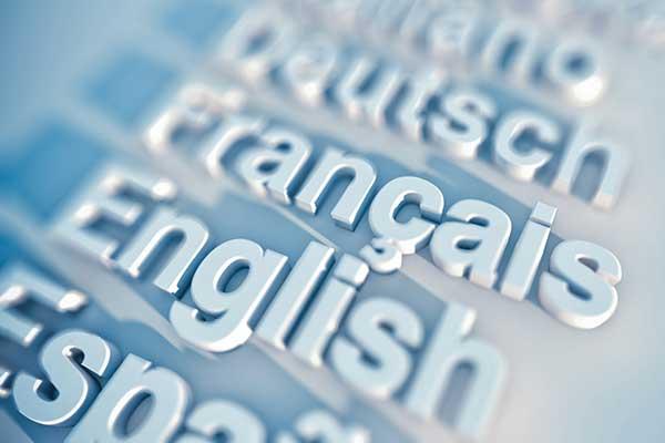 Global languages word cloud with keywords on blue computer keyboard - french, english, spanish and more
