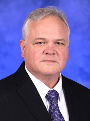 Peter Ostasewski, in a professional head and shoulders photograph.