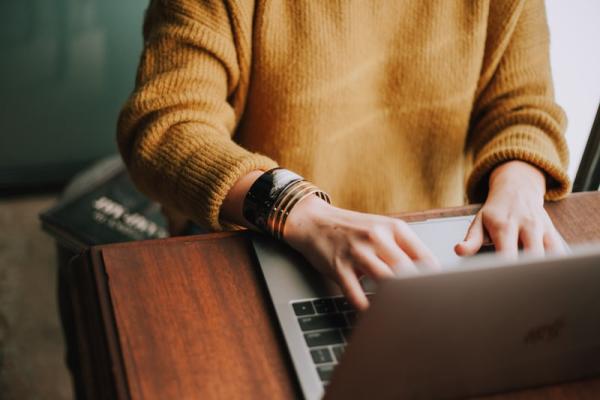Woman in a yellow sweater uses the computer